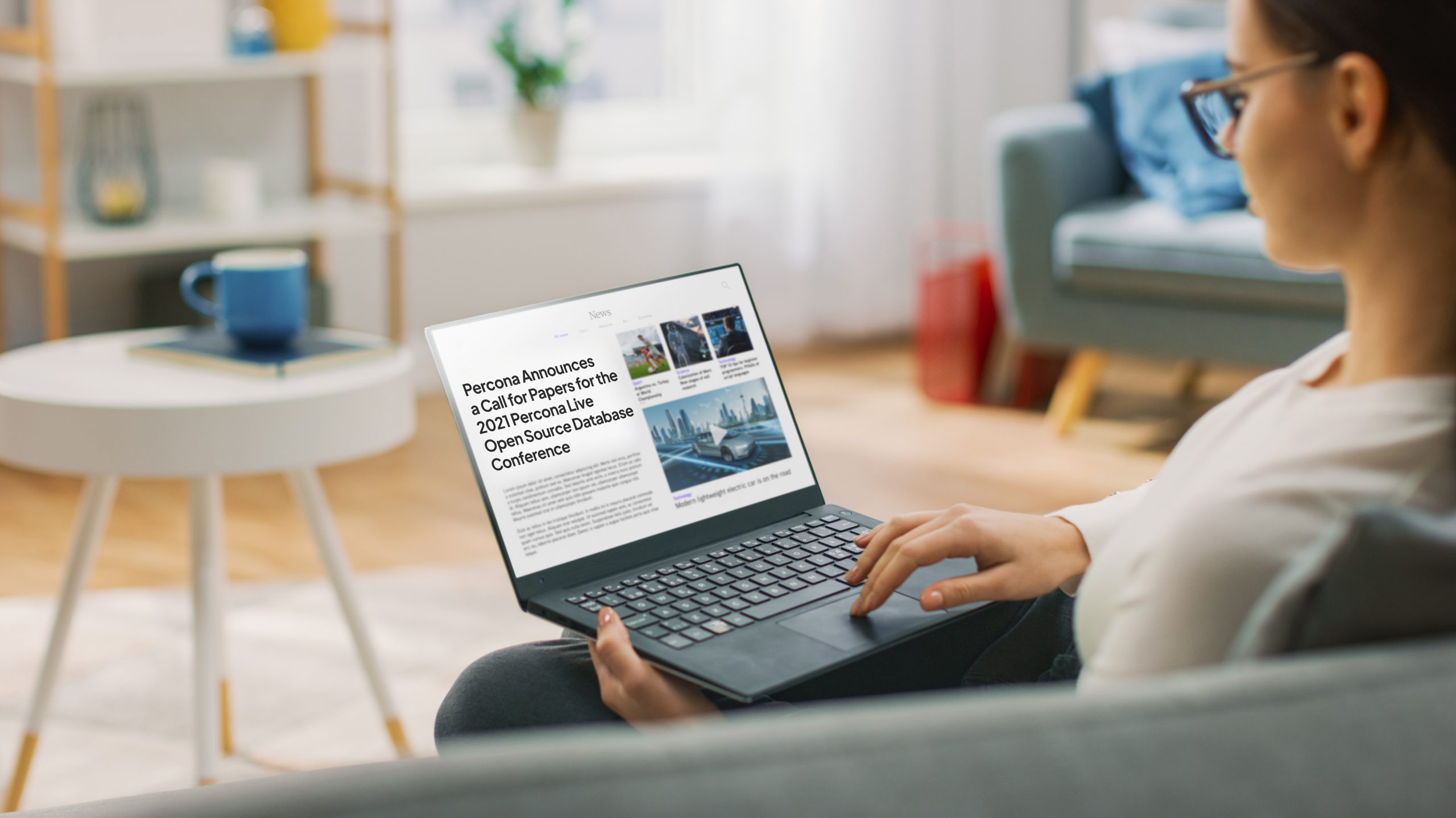 Young Woman at Home Is Using Laptop Computer for Scrolling and Reading News about Technological Breakthroughs. She’s Sitting On a Couch in His Cozy Living Room. Over the Shoulder Shot